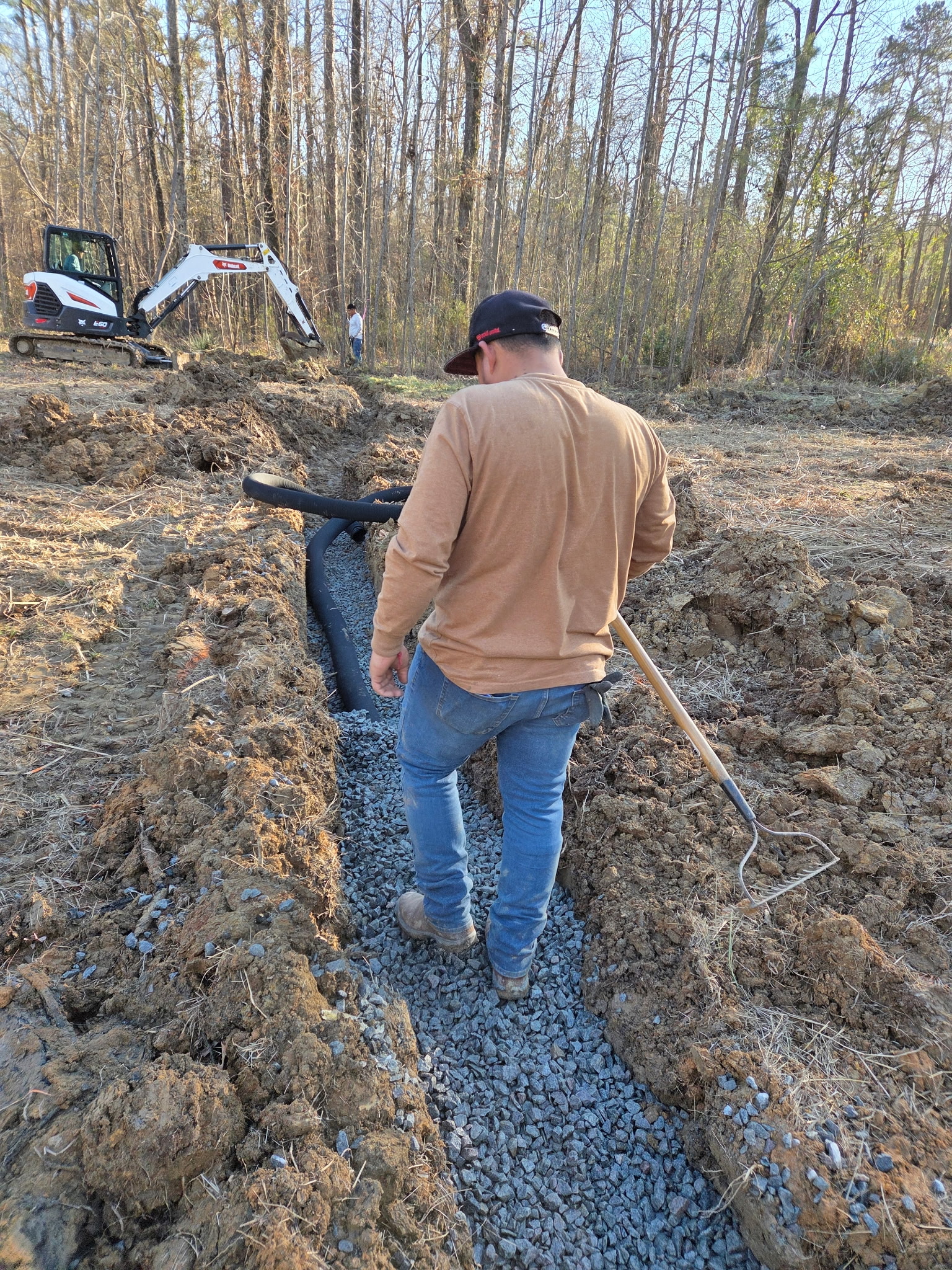 Drain solution installation with excavation equipment and gravel trench