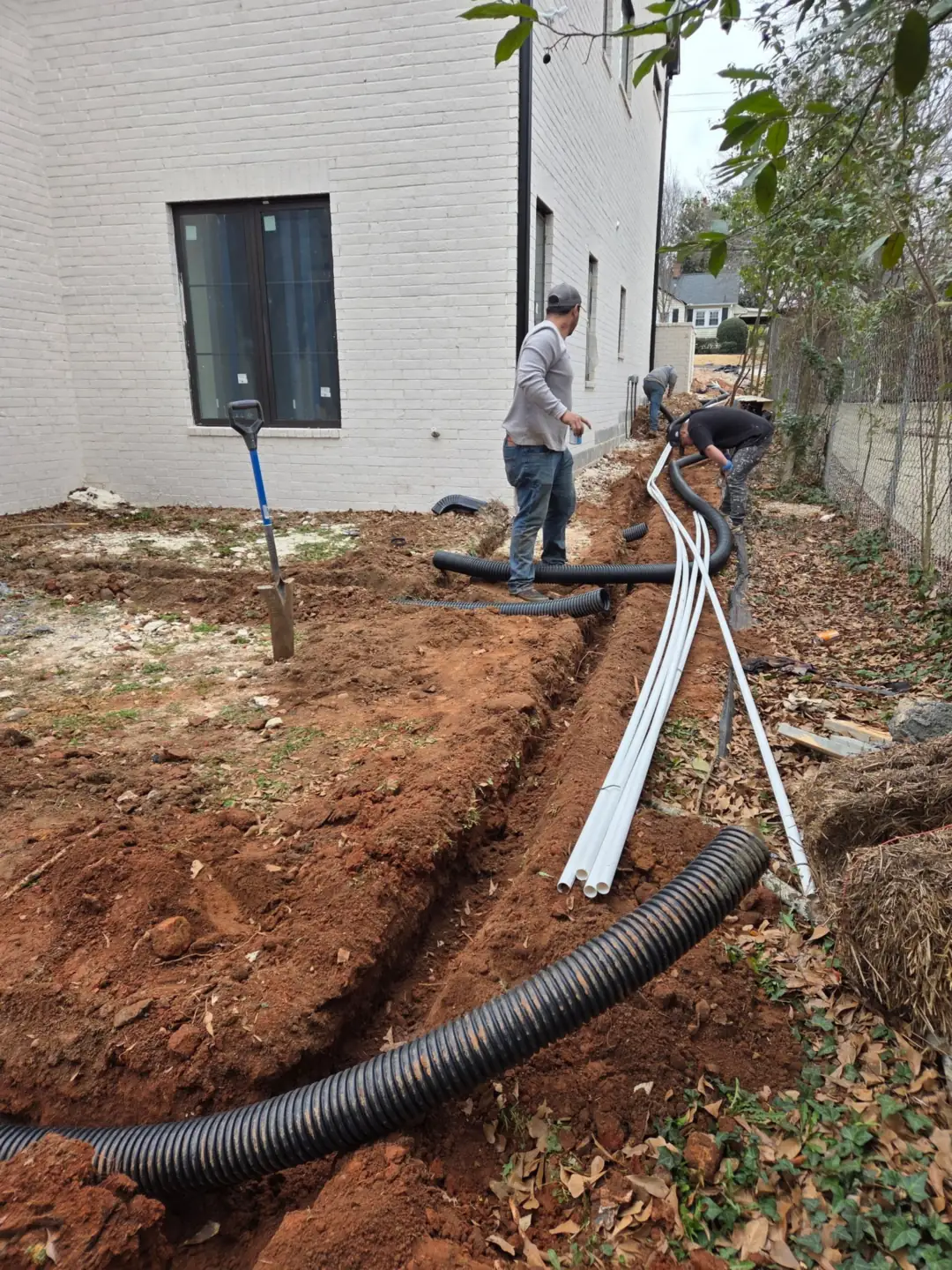 Emanuel's Landscaping crew laying drain pipe on a residential job in Columbia, SC